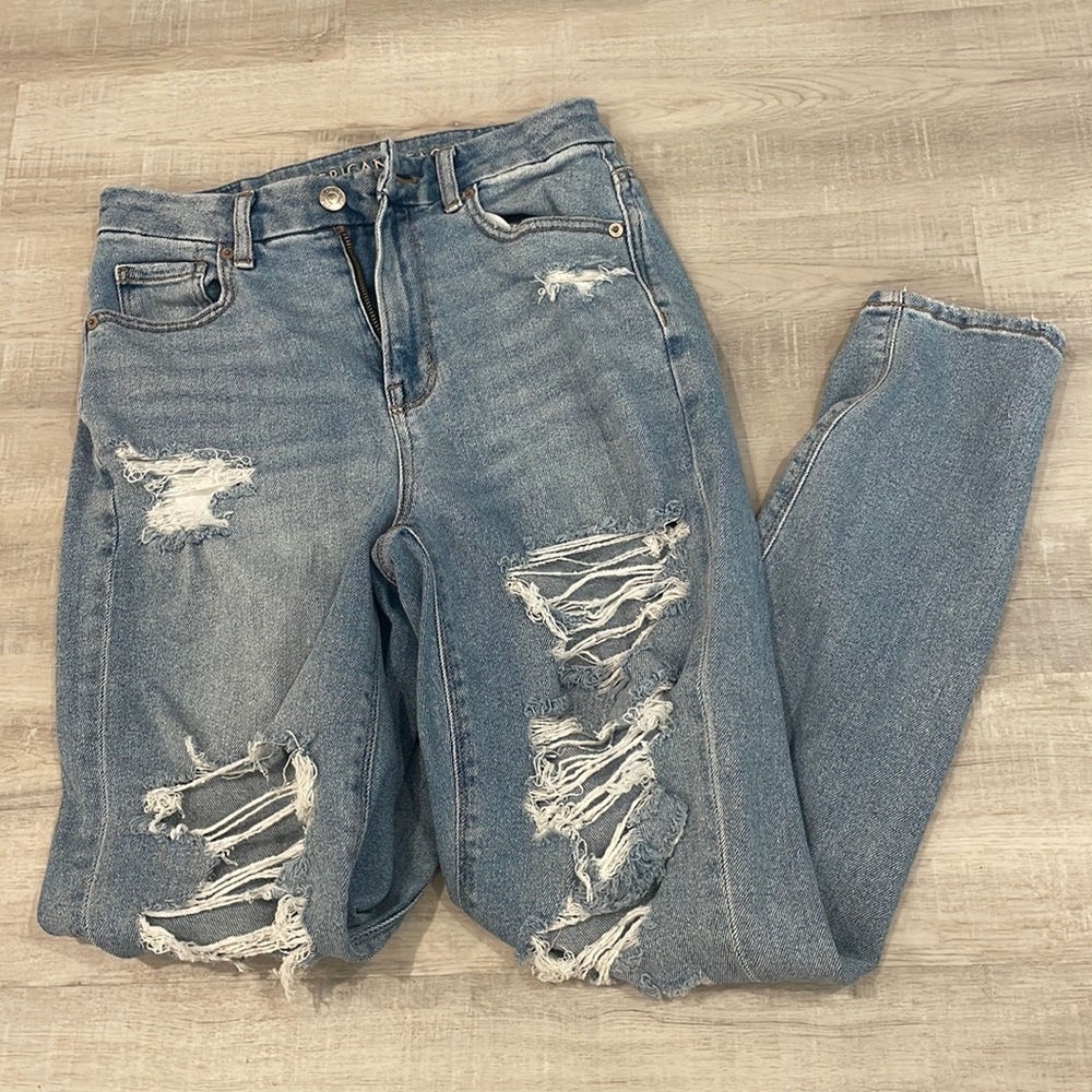 American Eagle medium wash curvy mom jeans with many rips.